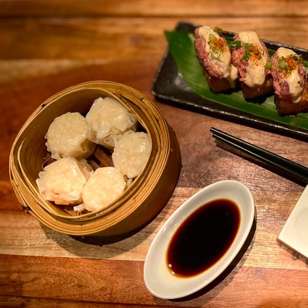Kameya Sushi appetizers: steamed dumplings in a bamboo basket, and tuna tartare on crispy rice.