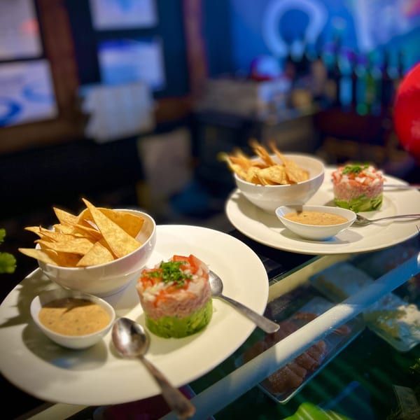 Two plates of Kameya Sushi's tuna tartare with avocado, tortilla chips, and dipping sauce.
