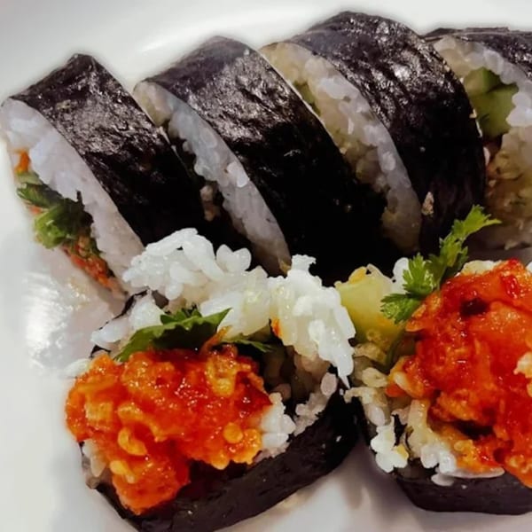 Kameya Sushi's spicy tuna rolls, with vibrant red tuna and white rice, on a white plate.